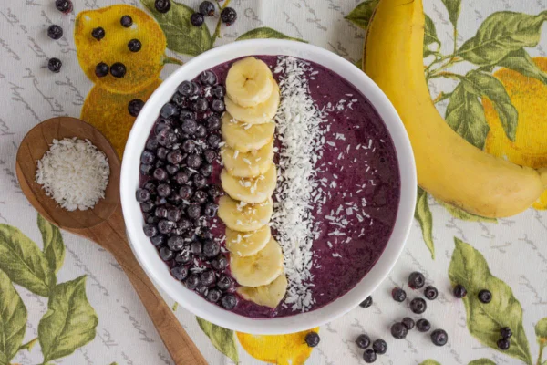 Imagem colorida de pote com açaí, banana e frutas