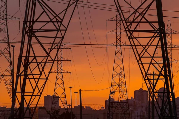 Postes de energia e no fundo o pôr do sol