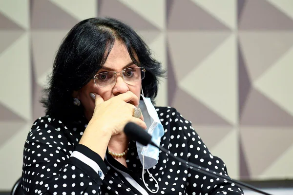 Ministra da Mulher, da Família e dos Direitos Humanos, Damares Alves, depõe em audiência no Senado. Ela usa máscara, sentada à mesa, e olha para frente - Metrópoles