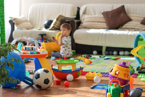 Criança brincando na sala de casa com brinquedos