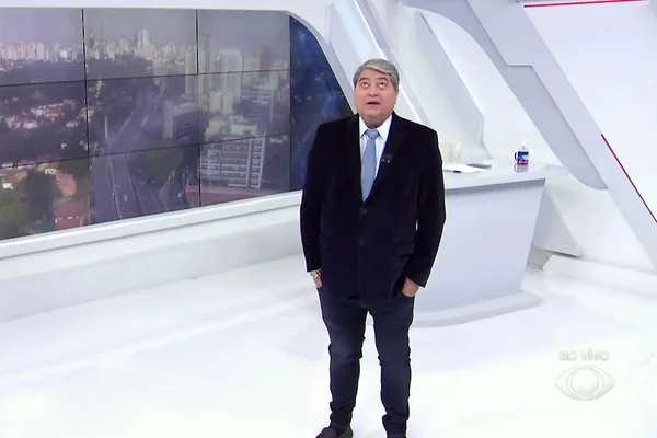 Imagem mostra o apresentador José Luiz Datena. Ele usa um terno preto e gravata azul e está em um estúdio de TV - Metrópoles