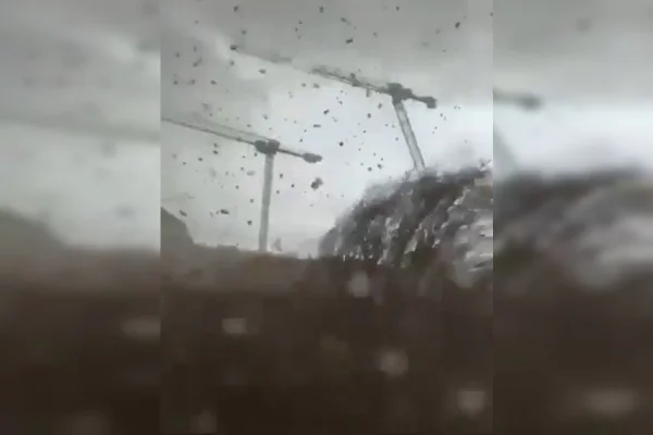 Imagem colorida de tornado derrubando guindastes