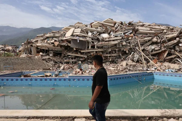 Homem caminha entre os escombros de prédios demolidos após um terremoto de magnitude 7,2 atingir a Venezuela