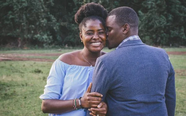 Casal feliz, homem de costas beijando mulher
