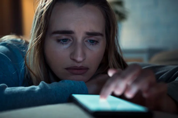Imagem colorida de mulher verificando notificações angustiadas