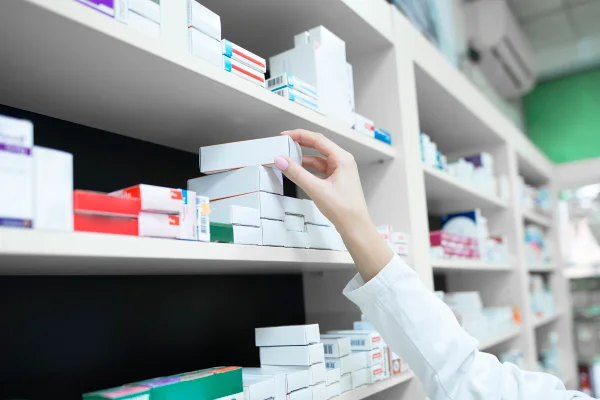 Foto colorida de pessoa buscando medicmaneto em pratileira - Metrópoles.
