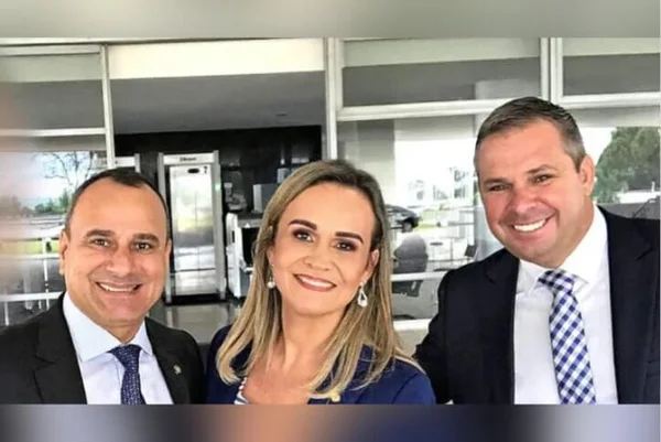 Ministra do Turismo, Daniela Carneiro, ao lado do bombeiro Márcio Pagniez, acusado de envolvimento com a milícia. Ela sorri, com mais um homem na foto, em frente a repartição pública - Metrópoles