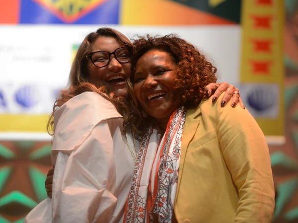 A primeira-dama Janja ri e abraça a ministra da Cultura, Margareth Menezes, durante cerimônia
