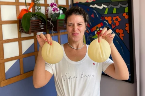 Foto mostra Renata Lucena, que retirou os implantes de silicone, mostrando-os apoiados nas mãos para a câmera - Metrópoles