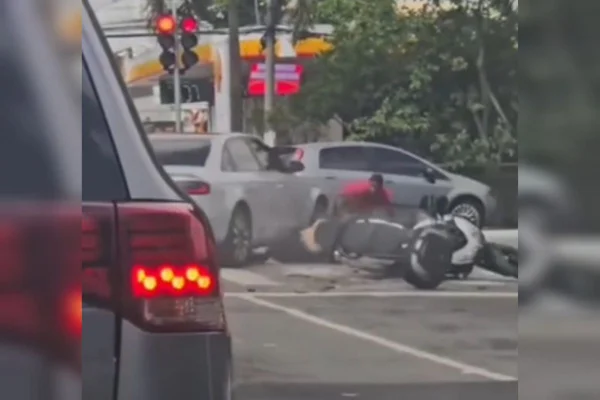 Carro atropela homem de camiseta vermelha, um dos assaltantes que roubou moto, em faixa de pedestres - Metrópoles