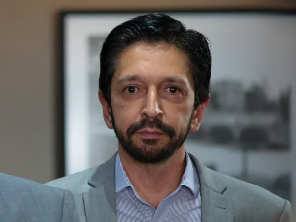 Imagem colorida mostra Ricardo Nunes, do peito para cima, de terno, olhando para frente. Ele é um homem branco de cabelo e barba pretos - Metrópoles