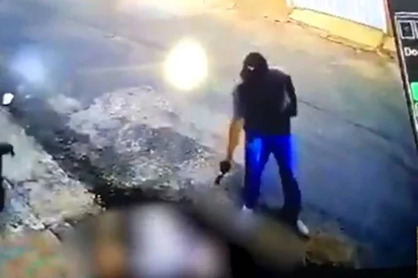 Imagem colorida mostra homem atirando em pessoa ao chão
