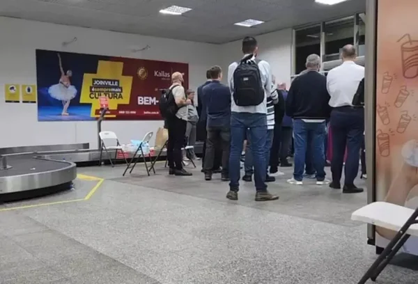 Imagem colorida de passageiros esperando operação da PF em aeroporto de Joinville (SC) - Metrópoles