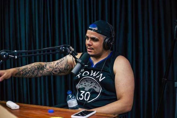 Foto de um homem de regata de basquete em um podcast - Metrópoles