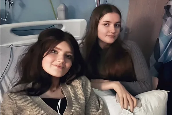 Imagem colorida: irmãs gêmeas sentadas em cama de hospital - Metrópoles