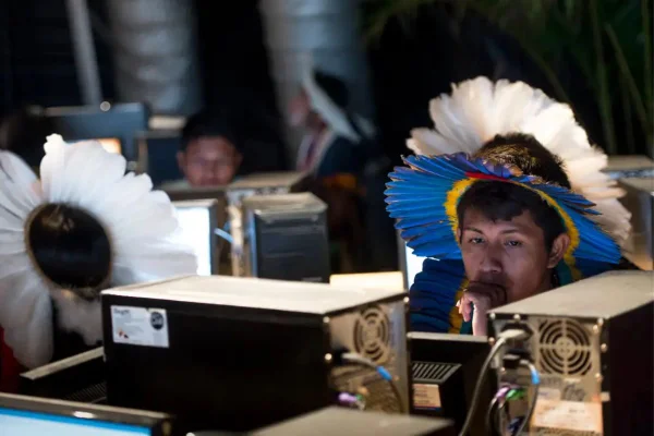 Foto colorida de indígena mexendo em um computador - Metrópoles