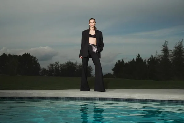 Na imagem com cor, modelo posa com looks de Victoria Beckham - Metrópoles