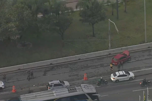 Imagem colorida feita do alto mostra pista de estrada com um carro vermelho atravessado após perseguição policial - Metrópoles
