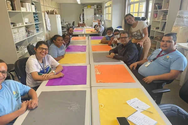 Mesa grande com alunos olhando para a foto