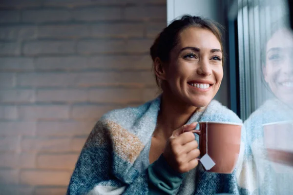 Imagem colorida de mulher feliz bebendo chá