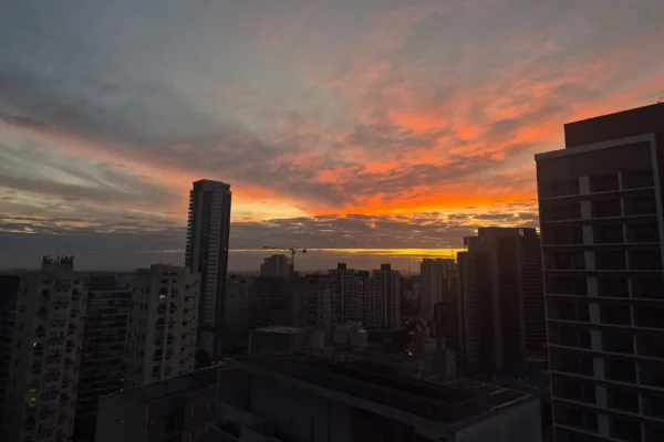 Imagem colorida mostra céu com tons misturados de azul e laranja ao amanhecer - Metrópoles