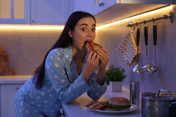 Foto colorida - mulher comendo sanduíche