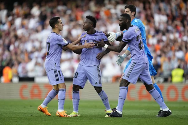 Imagem colorida mostra Vinicius Junior reage a ataques racistas vindos da torcida do Valencia, enquanto seus companheiros do Real Madrid o seguram - Metrópoles