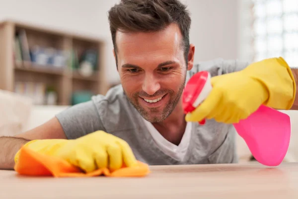 Foto colorida de homem limpando a casa