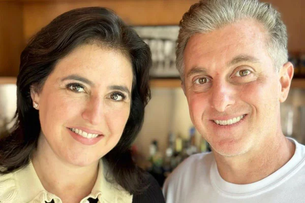 Simone Tebet e Luciano Huck posam lado a lado sorrindo - Metrópoles