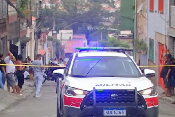 Viatura da PM isola rua, onde estão dezenas de pessoas; pai e filho foram mortos a tiros - Metrópoles