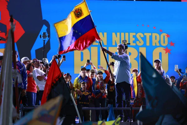 Imagem colorida mostra Nicolás Maduro agitando uma bandeira da Venezuela observador eleições - Metrópoles