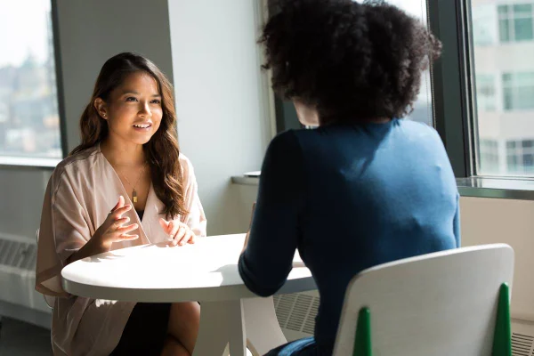 Foto colorida de duas mulheres conversando