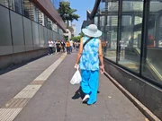 Mulher caminha de chapéu sob sol em trecho da Avenida Paulista