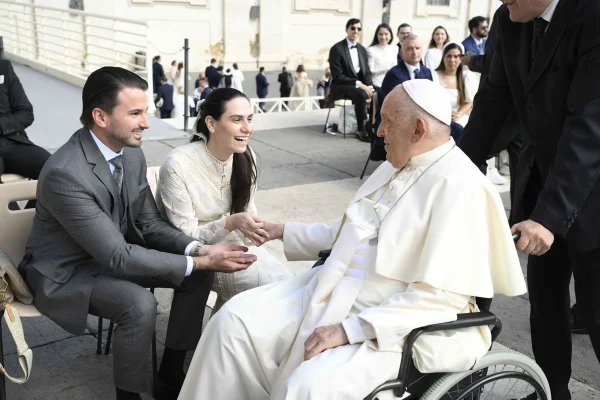 Foto colorida de casal sentado falando com o papa Francisco - Metrópoles