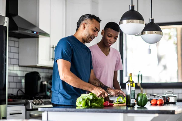 Homens em frente a mesa com ingredientes saudáveis para cozinhar