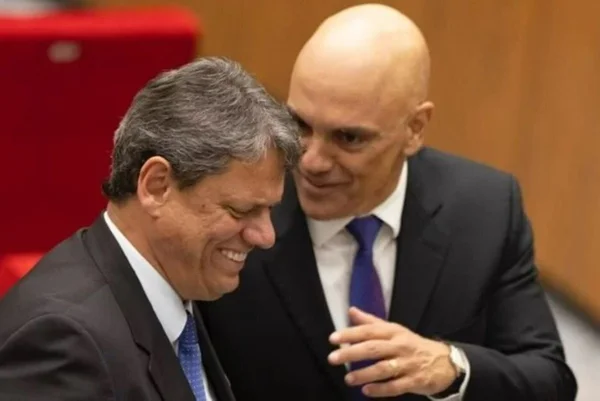 Imagem colorida mostra dois homens brancos vestidos de terno e gravada, conversando sorridentes. Eles são Tarcísio de Freitas e Alexandre de Moraes - Metrópoles