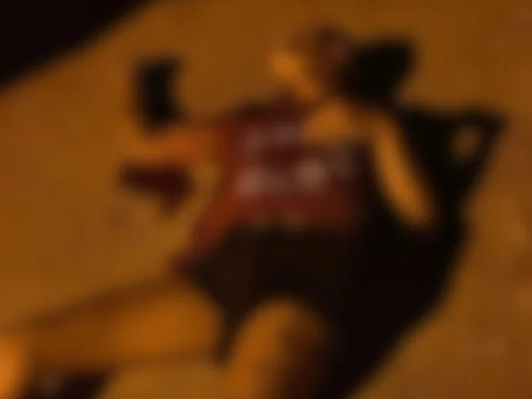 Foto colorida e borrada da travesti conhecida como Ketlin deitada no chão - Metrópoles