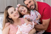 Thaeme, o marido e a primogênita posam juntos após o nascimento da cacula