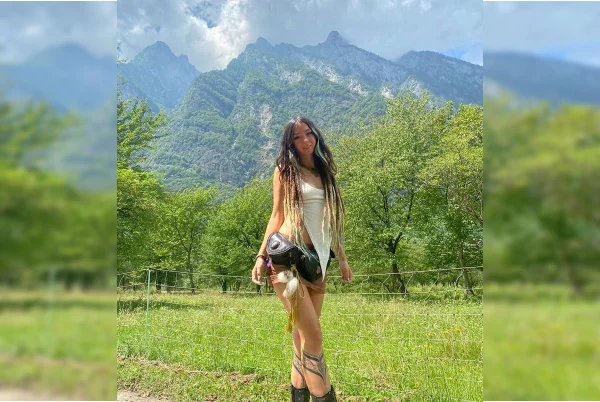 Imagem colorida mostra a Dj israelense Shani Louk posando para foto com paisagem de fundo - Metrópoles