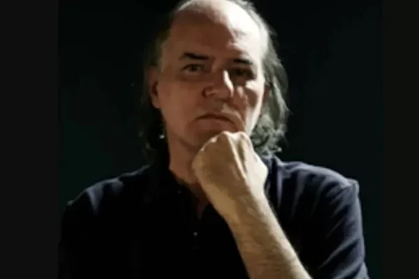 Foto colorida do jornalista Carlos Roberto Amorim com a mão no queixo - Metrópoles