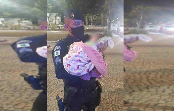 Policial segura criança no colo