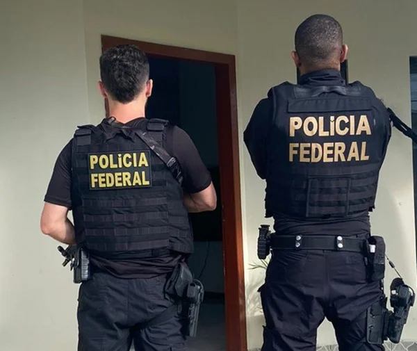 Imagem colorida de costas de policiais federais - Metrópoles