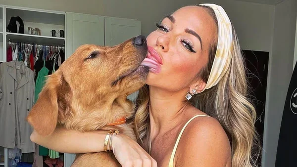 Foto colorida de influenciadora Maddy Burciaga com cão golden retriever