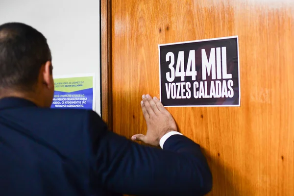 Assessor cola cartaz com a mensagem “344mil vozes caladas” no Gabinete do Deputado Federal Deltan Dallagnol, que teve o mandato cassado - Metrópoles