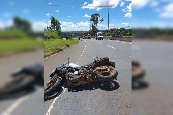 Moto caída e, ao fundo, viatura dos bombeiros