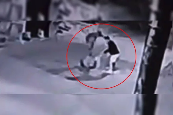 Foto em preto e branco que mostra os dois criminosos agredindo um policial militar no Gama. A arma do PM foi roubada