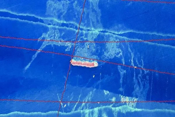 Na imagem, as manchas mais claras, esmaecidas, são o óleo que cerca a embarcação.