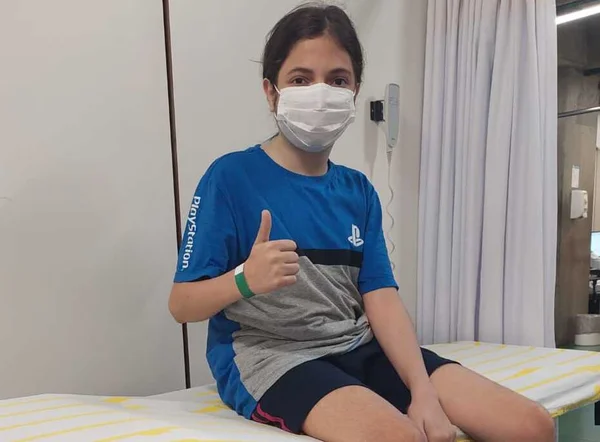 Carlos sentado na maca do hospital em uma de suas internações