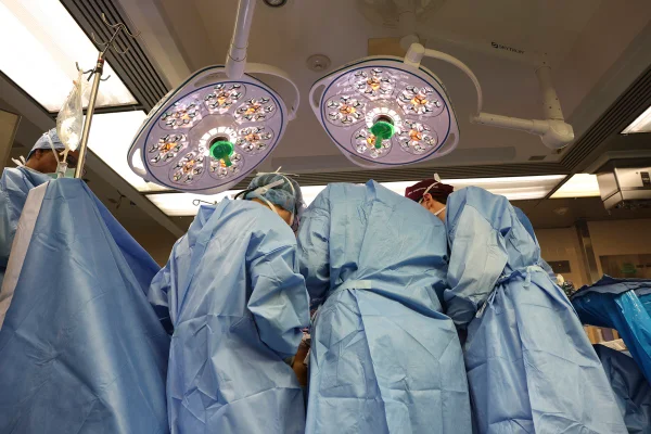 Foto mostra equipe médica paramentada em sala de cirurgia para transplante