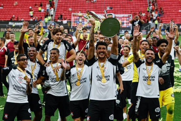 Foto colorida dos jogadores do Corinthians levantando a taça da Supercopa do Brasil - Metrópoles